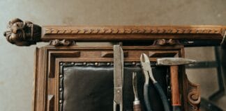 Stare narzędzia na rzeźbionym drewnianym krześle do renowacji tapicerki